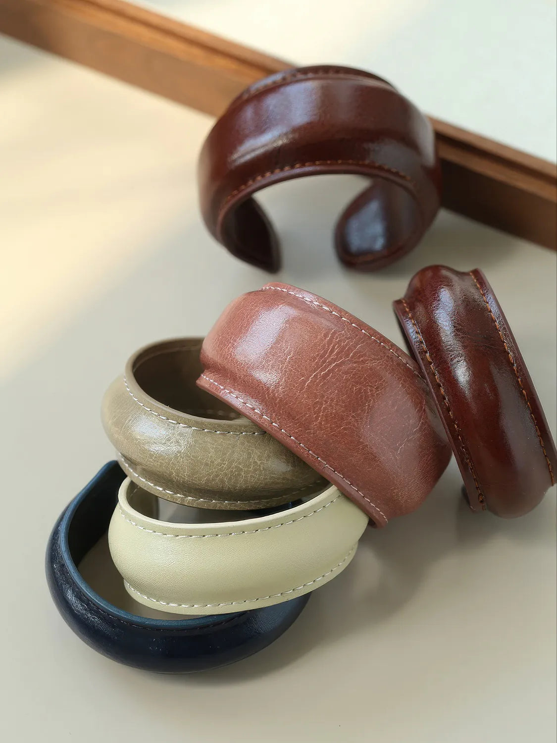 Set of leather bangles in various colors on a light surface